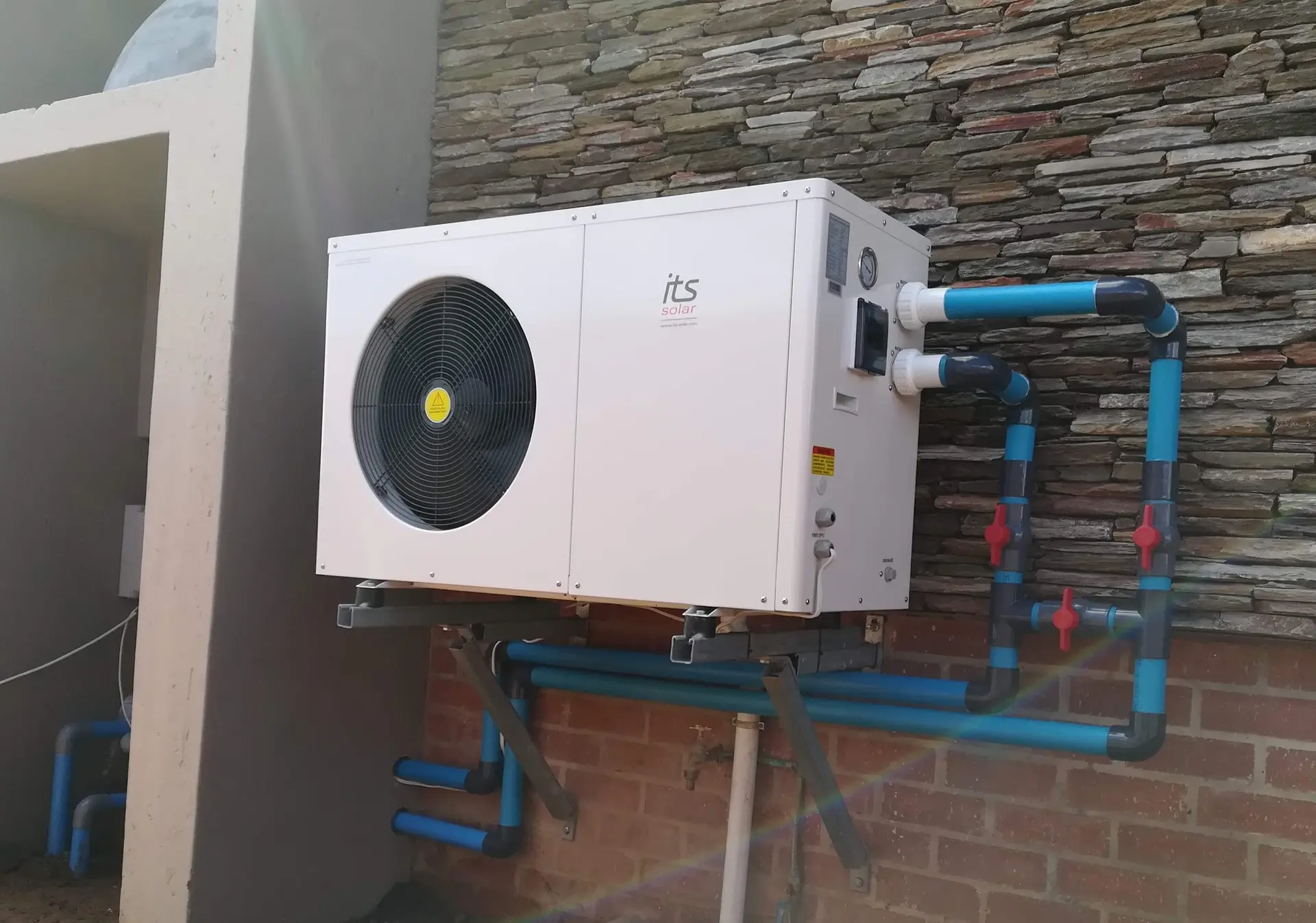 A heat pump on an outside wall